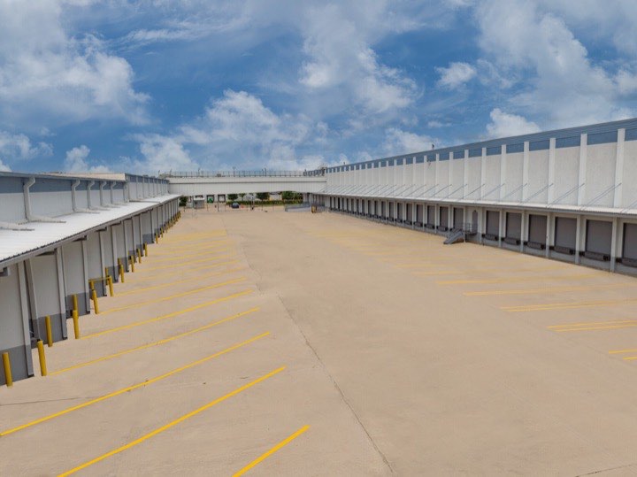 A wide concrete apron running between two rows of loading docks at the Ernestine Street campus.