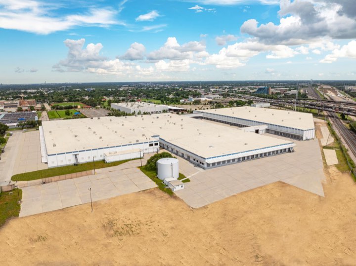 Aerial view of the full campus from the corner, with the laydown yard in the foreground.